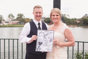 Disney wedding couple poses with their caricature during their Epcot reception captured by Orlando wedding photographer
