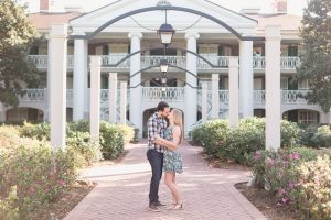 Romantic engagement photo under the archway at Disney resort after a surprise proposal captured by top Orlando wedding photographer