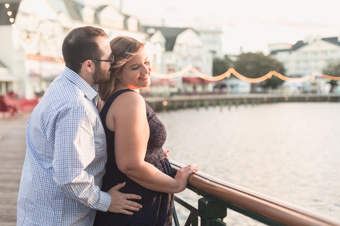 Orlando engagement photographer captures couple overlooking the water at Disney Boardwalk during their photo shoot
