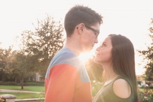 Engagement photography session at Rollins in Winter Park featuring beautiful sunlight peeking from behind the engaged couple