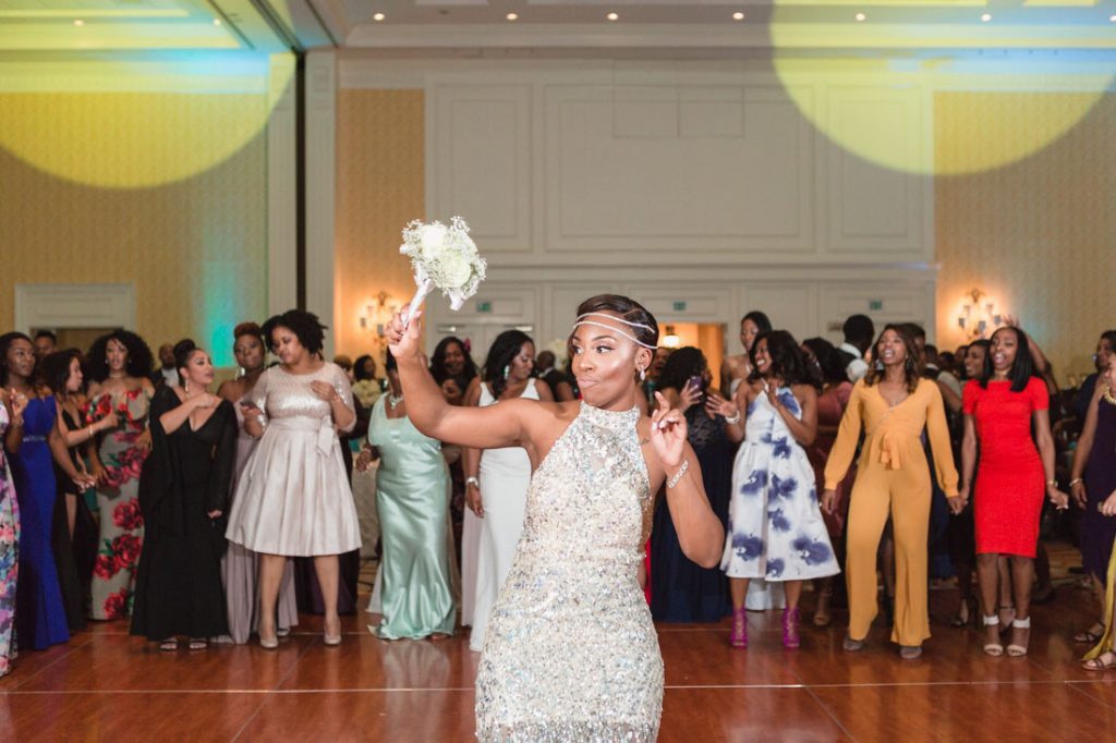 Bride throwing the bouquet at her Orlando wedding captured by top photographer Captured by Elle