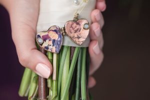 Bride honors father with a locket pinned to her bouquet captured by Orlando wedding photographer