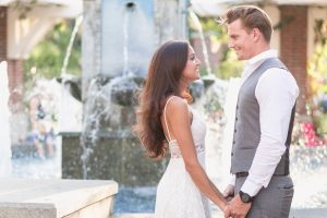 Romantic engagement photo with couple embracing in front of a fountain in historic downtown Winter Garden during their engagement portrait session with top Orlando wedding photographer