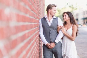 Romantic engagement photography session in historic downtown Winter Garden on a red brick wall captured by top Orlando wedding photographer and videographer