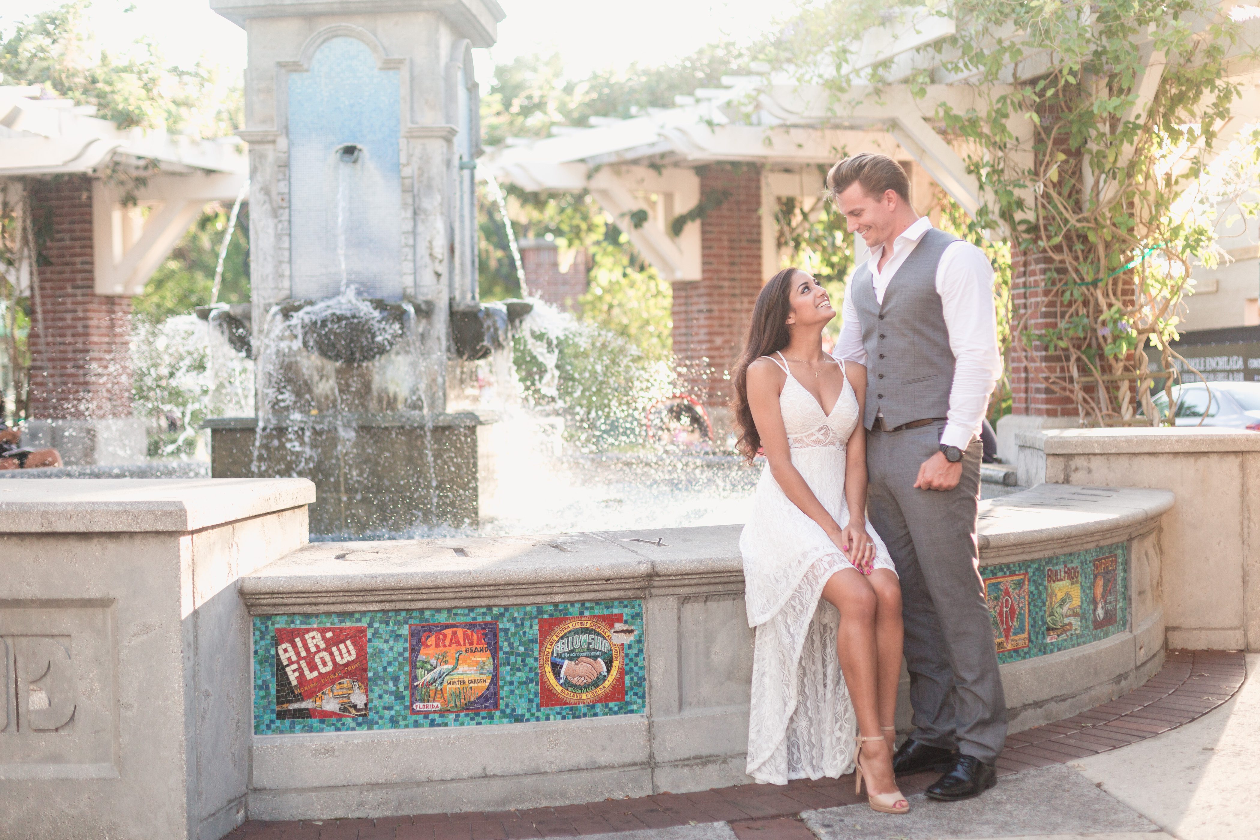 Engaged couple poses in front of a beautiful fountain in the heart of historic Winter Garden for their engagement photography session with top Orlando wedding photographer Captured by Elle