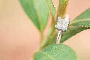 Engagement ring close up on a plant at Kraft Azalea gardens during this romantic Winter Park engagement shoot