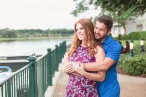 Couples cuddles during their candid engagement photography session with top Disney photographer