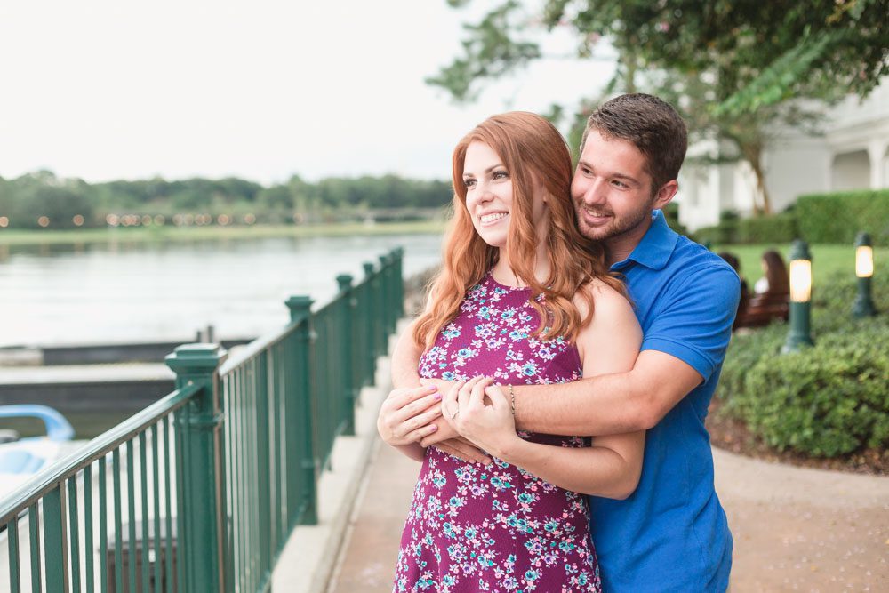 Couples cuddles during their candid engagement photography session with top Disney photographer