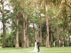 LGBT Wedding photography surrounded by gorgeous tall trees at Kraft Azalea garden in Winter Park