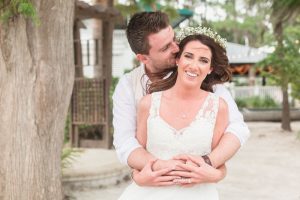 Romantic portrait of the bride and groom during their tropical beach wedding at Paradise Cove captured by top Orlando wedding photographer