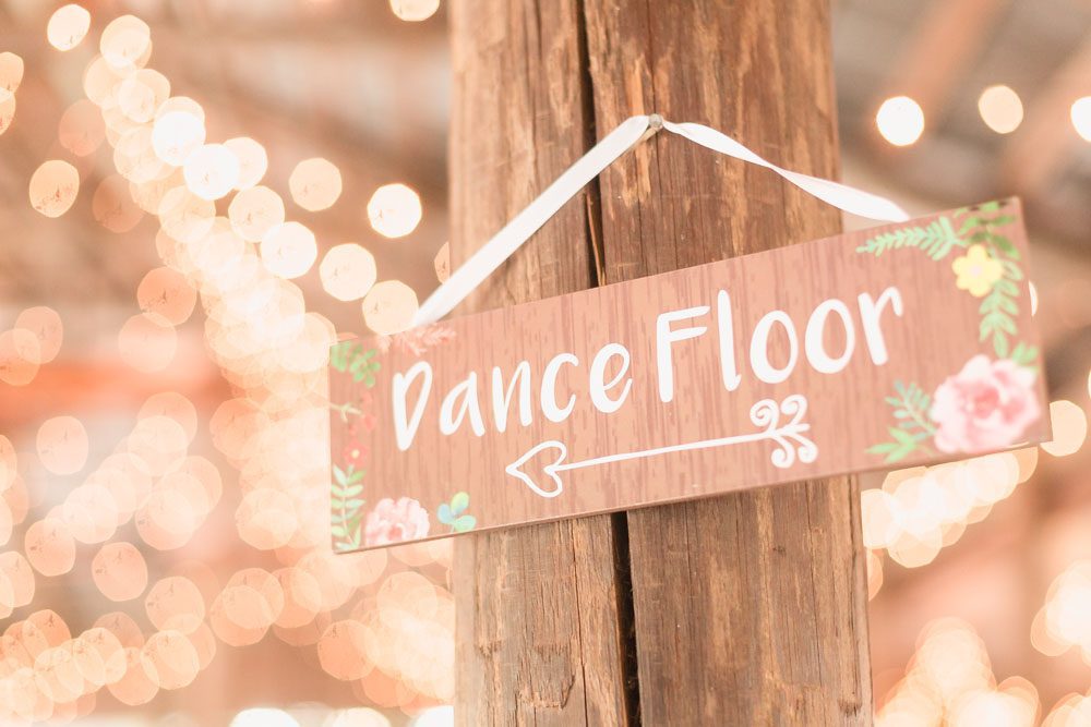 Adorable 'Dance Floor' sign pointing guests to the party at this paradise cove wedding reception in Orlando
