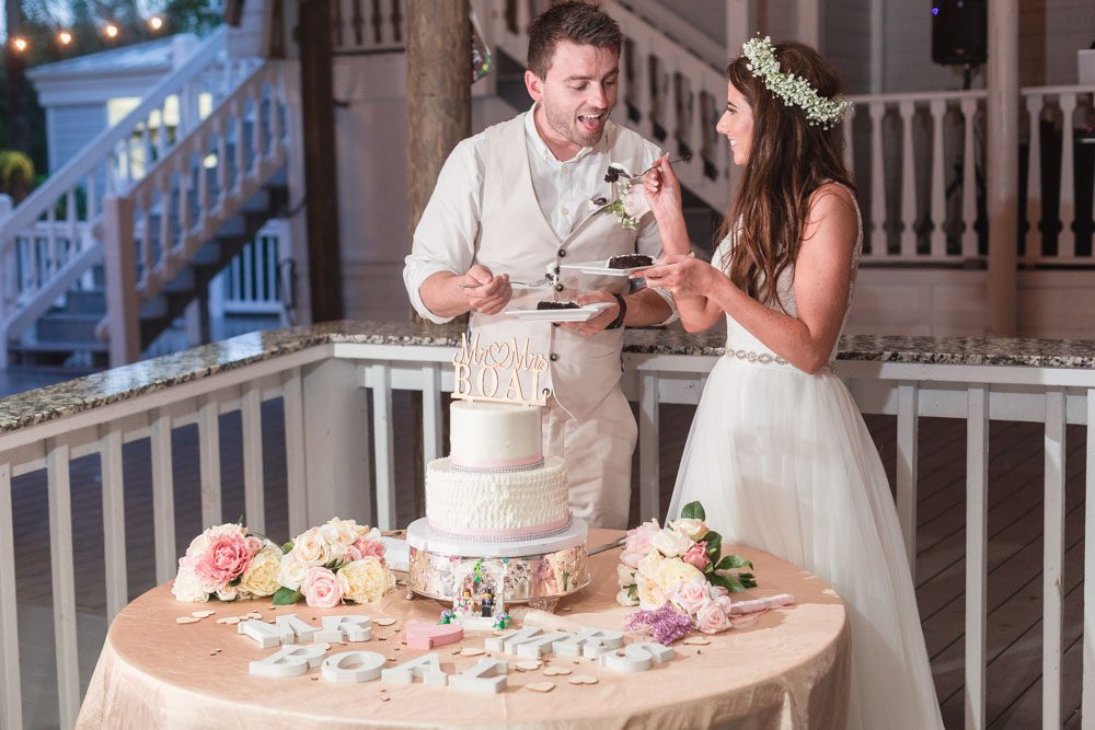 Sharing a slice of wedding cake at their reception under the pavilion at Paradise Cove in Orlando Florida