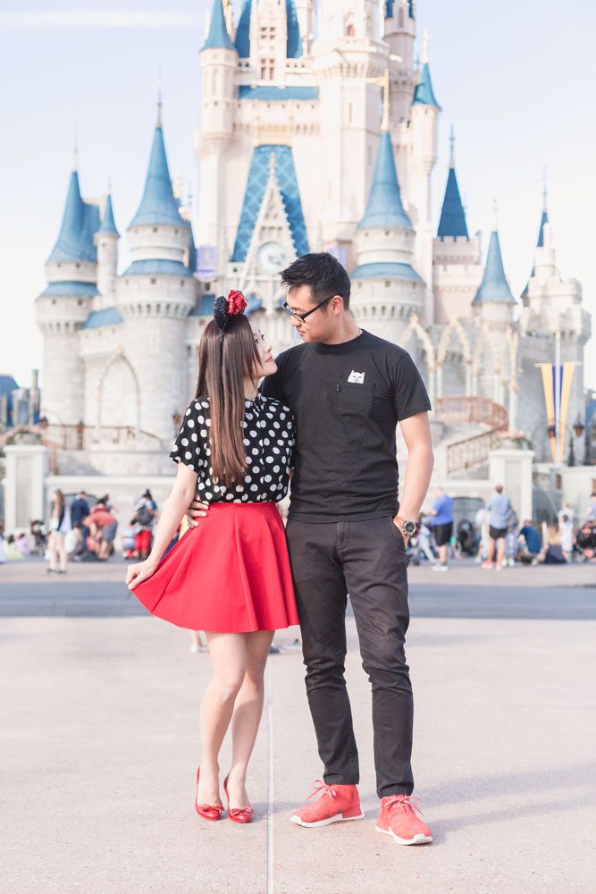 Engaged couple in front of the Walt Disney World Cinderella castle in Orlando for a fun photo shoot with top photographer