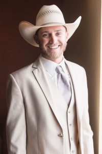 Groom wearing a cowboy hat and grey suit with vest for his country chic wedding day north of Orlando in Central Florida