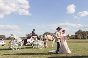 Horse drawn carriage picks up bride for her country chic wedding day at a barn in Central Florida captured by top Orlando photography team