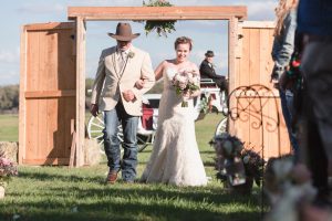 Bride enters through two large barn style doors for her country wedding ceremony in Central Florida