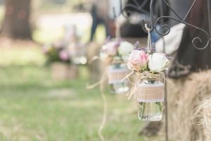 Rustic country decor featuring mason jars and burlap alongside hay bales for an outdoor wedding in central Florida