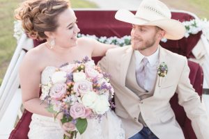 Bride and groom riding in a horse drawn carriage during their wedding portraits for their southern country wedding day in Orlando