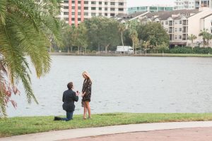 He gets down on one knee at Lake Eola in downtown Orlando for a surprise marriage proposal while a photographer captures the moment