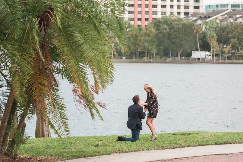 The future bride is caught off guard by this surprise proposal in downtown Orlando, Florida on the lake captured by top engagement and proposal photographer in Central Florida