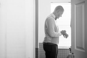 Black and white photo of the groom getting ready for his intimate wedding day in Kissimmee Florida