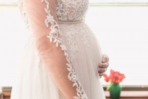 Close up shot of expectant bride's baby bump in her wedding dress captured by Orlando wedding photographer