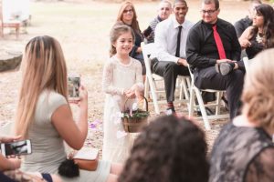 Flower girl walking down the aisle during a DIY boho wedding in Central Florida captured by top Orlando photography team