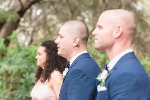 Groom's emotional reaction to seeing the bride down the aisle during their outdoor wedding ceremony in Kissimmee captured by top Orlando wedding photography team