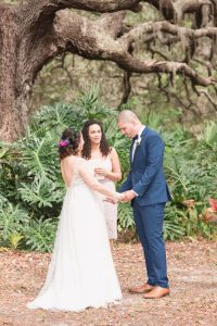 Bride and groom exchange vows under a beautiful tree during their outdoor wedding ceremony in Kissimmee photographed by top Orlando wedding photographer