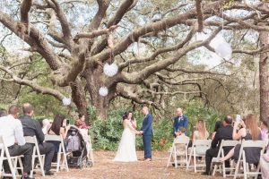 Beautiful wedding ceremony under a tree during a romantic backyard wedding captured by top Orlando photographer