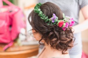 Bride shows off her curly up-do hairstyle and her floral crown for her intimate Orlando wedding