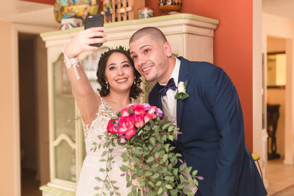 Fun wedding photo of the newlyweds taking a selfie after their wedding day in Central Florida captured by top Orlando wedding photographer and videographer