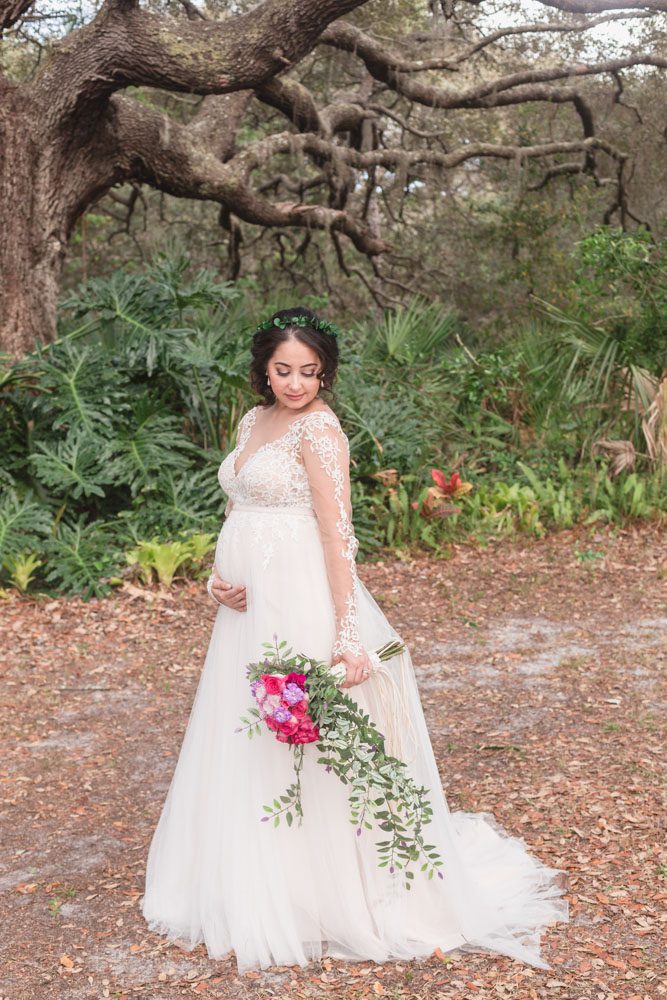 Portrait of the beautiful pregnant bride under a tree after an outdoor backyard wedding ceremony in Kissimmee, Florida captured by top Central Florida photography team