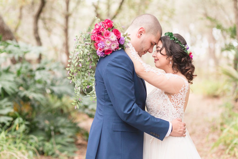 Top Orlando wedding photographer captures romantic photo of the bride and groom in the forest during their intimate DIY wedding in Kissimmee