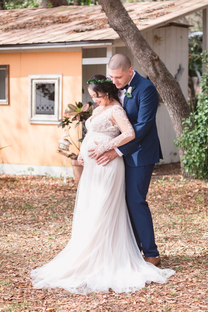 Orlando wedding photographer captures intimate portrait of expectant bride and groom featuring a beautiful pregnant bride during their Central Florida wedding day