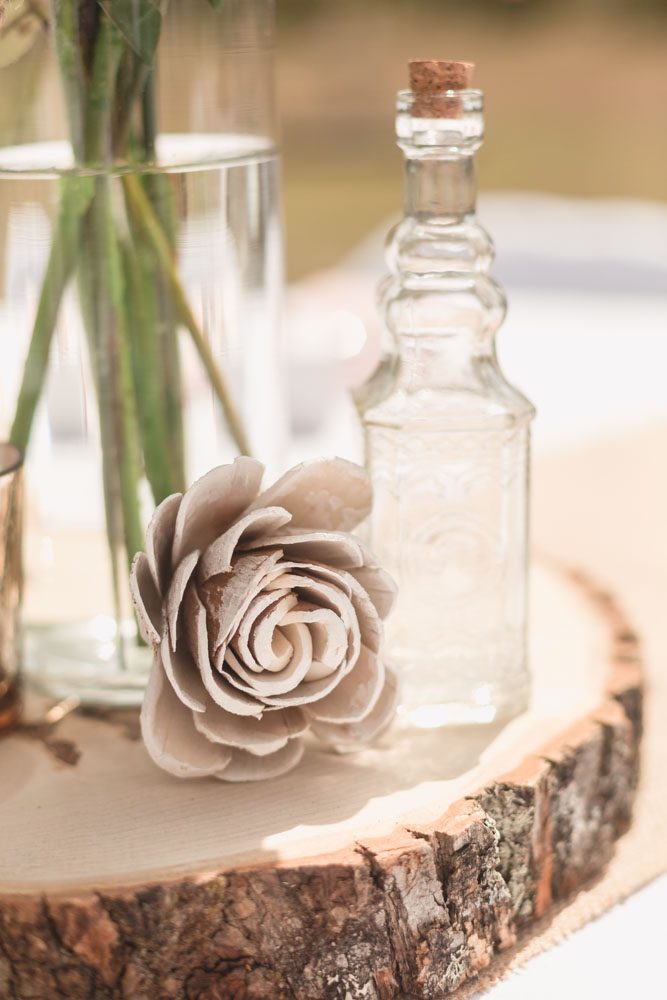 DIY handmade details for a rustic boho chic with wooden details and glass bottles for a beautiful centerpiece
