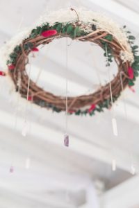 Gorgeous DIY handmade wreath chandeliers with rock crystals and flowers hung above guest tables in a beautiful outdoor wedding reception in Kissimmee, Florida captured by top Orlando wedding photographer