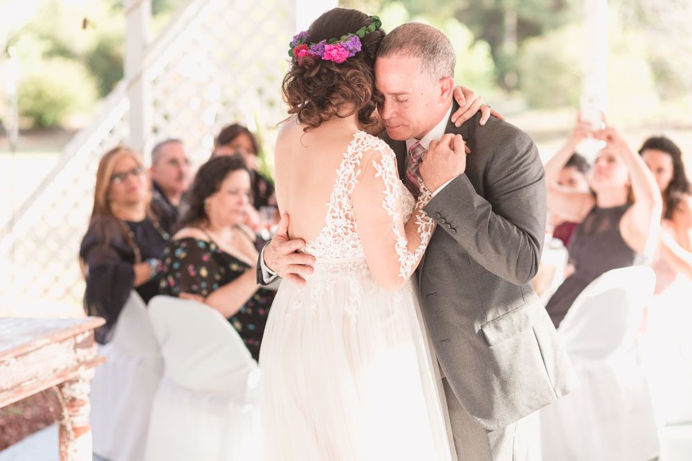 Bride shares an emotional first dance with her dad during their outdoor wedding reception in a backyard in Kissimmee, Florida