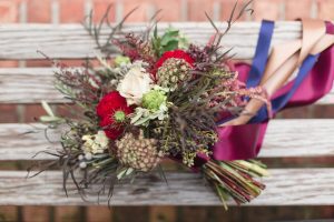 Wild burgundy and white bouquet with ribbons and greenery by top Orlando florist