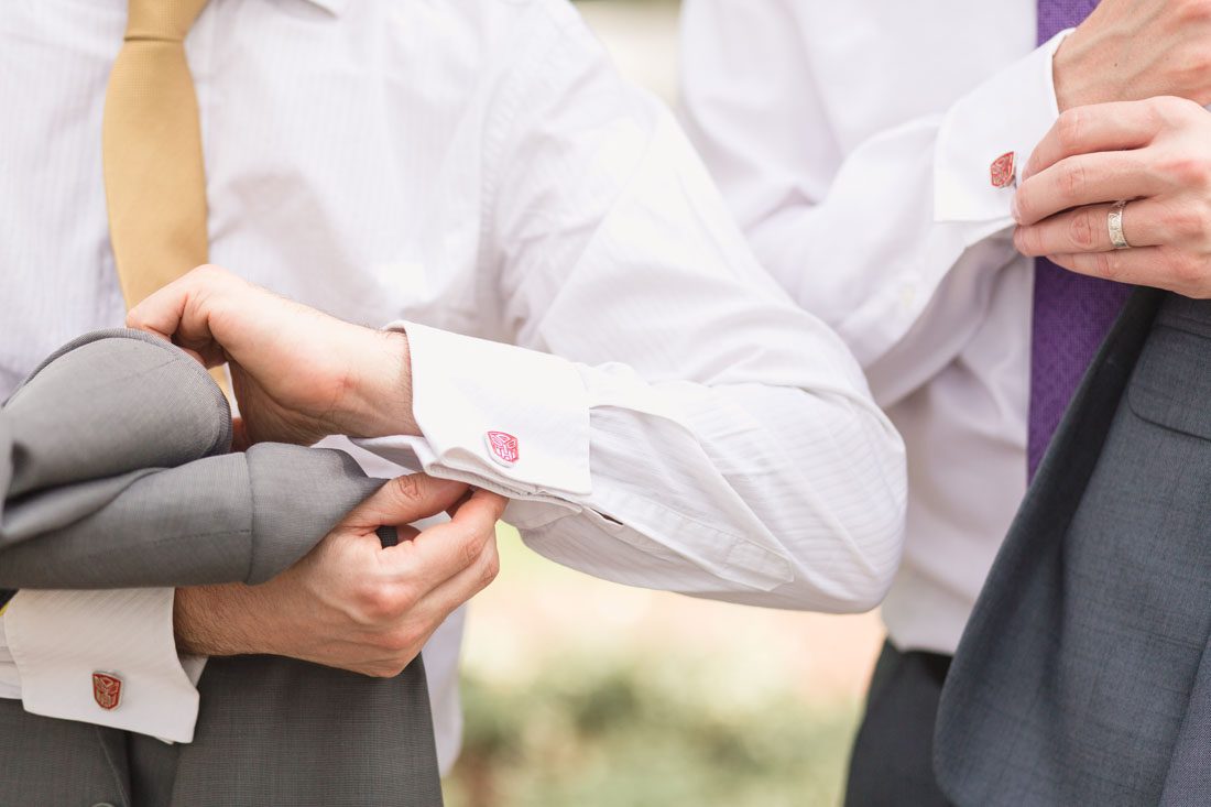 Groom and groomsman display their cuff links during a Disney themed elopement at Cypress Grove in Orlando