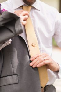 Groom displays his Tangled themed tie pin during a Disney themed elopement at Cypress Grove in Orlando