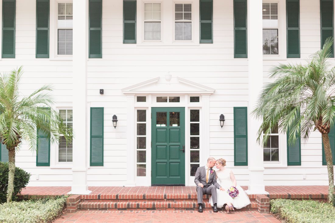 Orlando wedding photographer captures a romantic portrait of the bride and groom on the steps of the Cypress Grove Estate House venue in Orlando