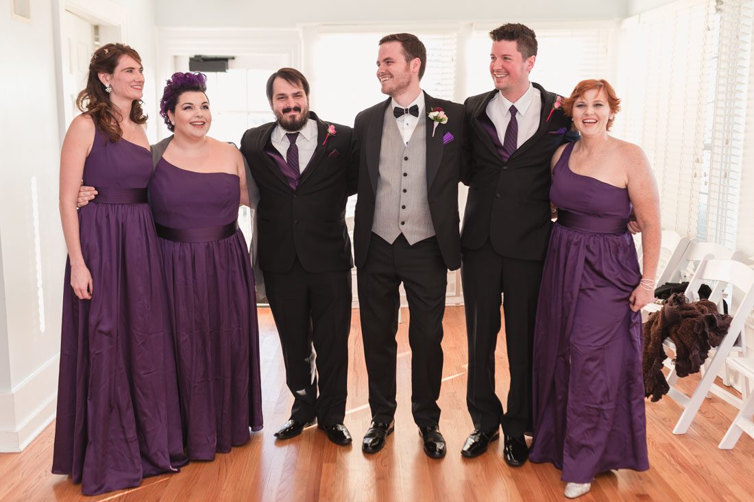 Photo of the wedding party wearing deep purple plum dresses at a gay Cypress Grove Estate House wedding in Orlando Florida