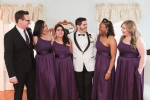 Photo of the wedding party wearing deep purple plum dresses at a gay Cypress Grove Estate House wedding in Orlando Florida