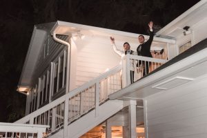 Grooms making their grand entrance from the balcony at their gay wedding in Orlando at Cypress Grove Estate House