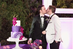 Photo of Grooms cutting the cake at their Orlando gay wedding at Cypress Grove outdoor venue
