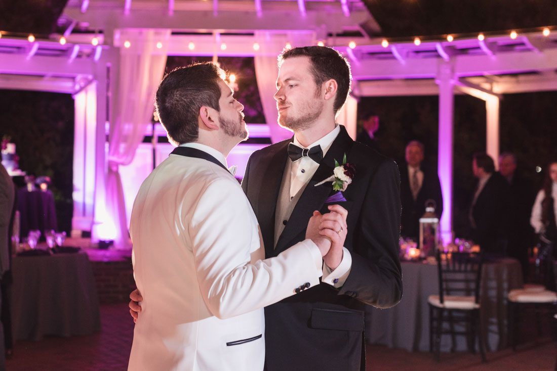 Candid photo during a gay Orlando wedding with the grooms sharing their first dance together at an outdoor venue in Orlando