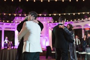 Candid photo during a gay Orlando wedding with the grooms sharing their first dance together at an outdoor venue in Orlando