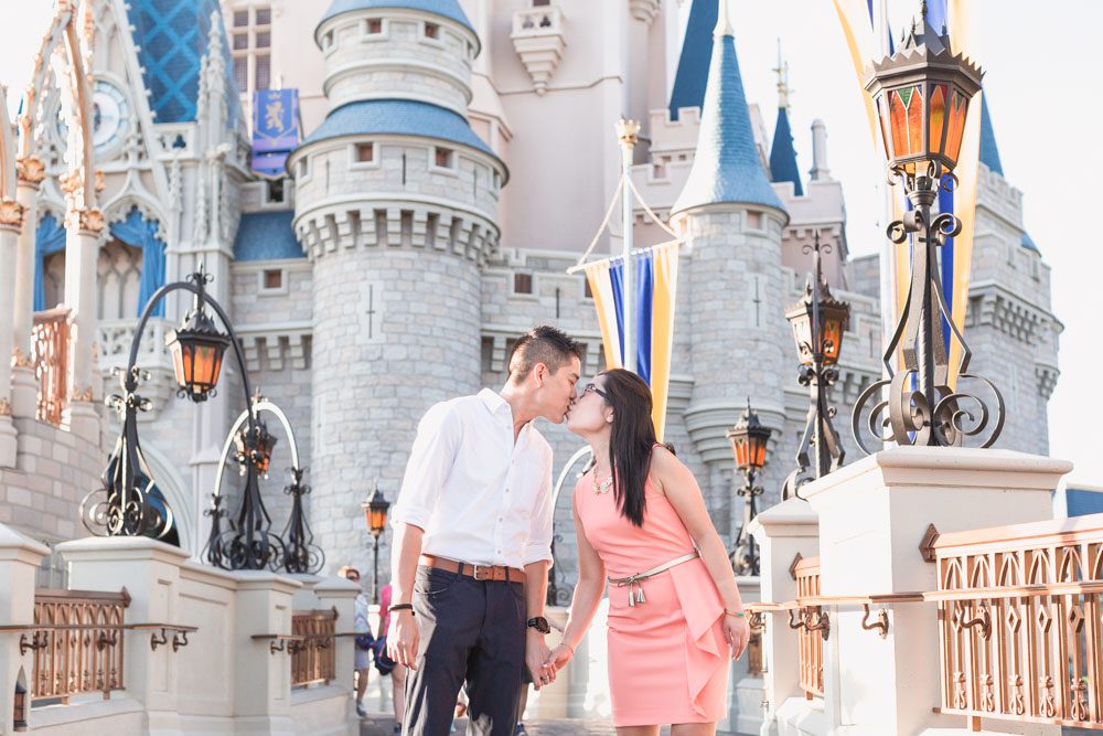 Engaged couple walking along Cinderella's castle at Walt Disney World park in Magic Kingdom during their engagement photography session in Orlando