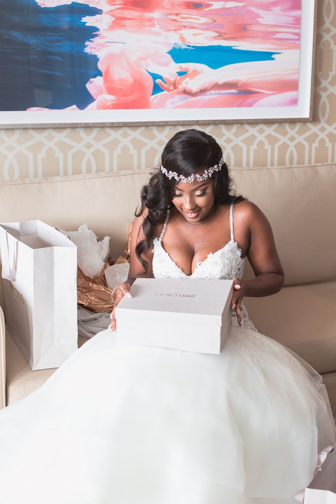 Bride opening her Jimmy Choo gift from her groom at the Four Seasons captured by wedding photographers in Orlando